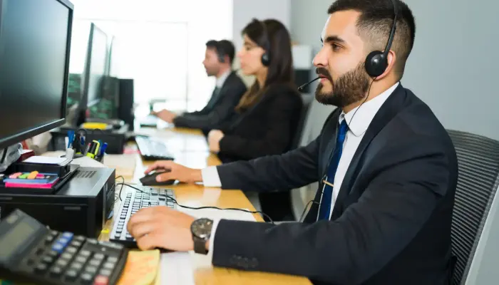 attractive-latin-executive-offering-customer-service-with-headset-offering-tech-support-busy-call-center-1-1